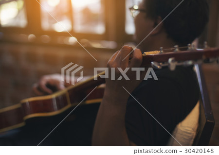 Relaxed man playing guitar Relaxed man playing guitar 30420148