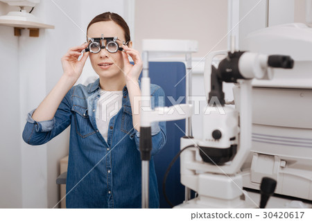 Beautiful good looking woman putting on eye test Beautiful good looking woman putting on eye test 30420617