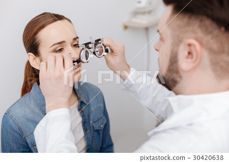 Professional male ophthalmologist preparing to do 30420638
