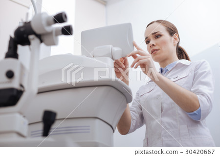 Good looking pleasant woman looking at the control 30420667