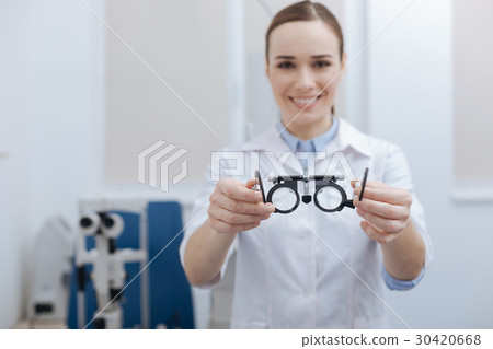 Eye test glasses being held by an optometrist Eye test glasses being held by an optometrist 30420668