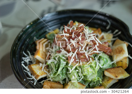 Ceasar salad in black bowl 30421264