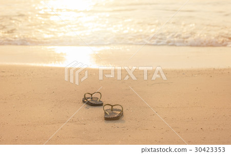 silhouette flip flop shoes on the beach in sunset  30423353
