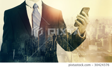 Double exposure of business man with smartphone and city 30424376