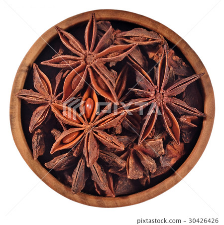 Star anise in a wooden bowl on a white 30426426