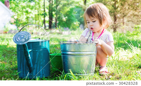 Happy toddler girl playing outside on a summer day Happy toddler girl playing outside on a summer day 30428328