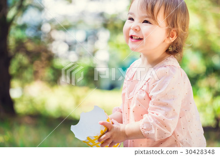 Portrait of a happy toddler girl playing with a big smile 30428348
