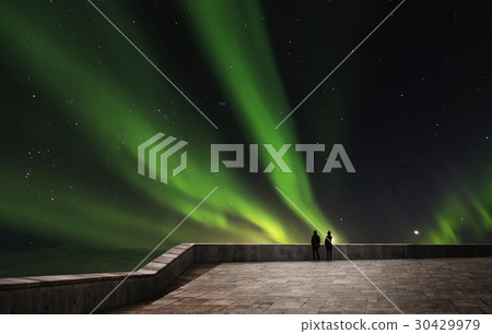 Couple enjoying beautiful Aurora Borealis at night Couple enjoying beautiful Aurora Borealis at night 30429979