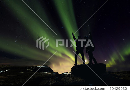 Silhouette men standing with Aurora Borealis Silhouette men standing with Aurora Borealis 30429980
