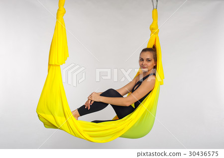 Beautiful yoga woman sitting in yellow hammock 30436575