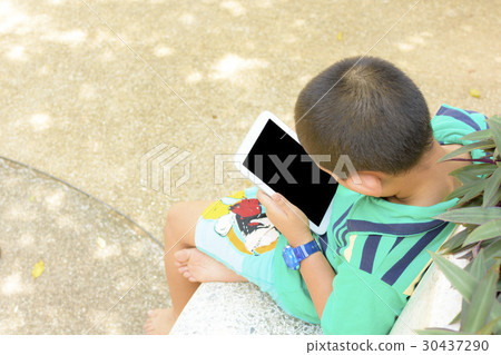 Child Asian using tablet computer in his hand in p 30437290
