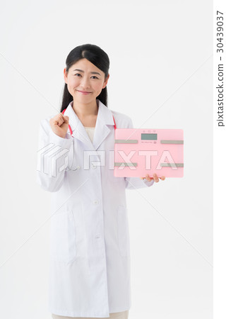 Female doctor with weight scale 30439037