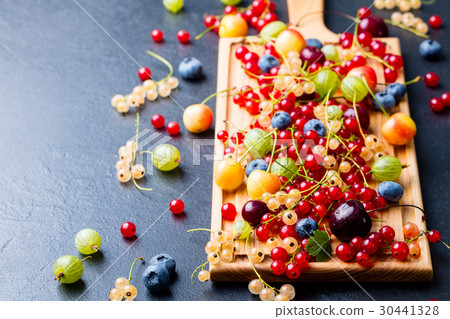 Fresh berries on wooden cutting board. Copy space Fresh berries on wooden cutting board. Copy space 30441328
