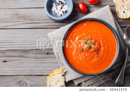 Tomato soup in a black bowl. Top view. Copy space. 30441559