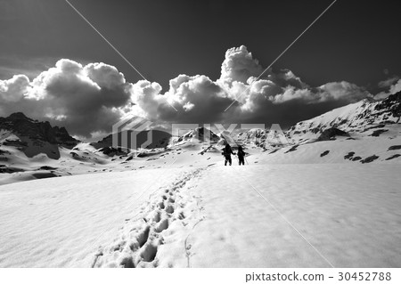 Black and white view on snow plateau with hikers. 30452788