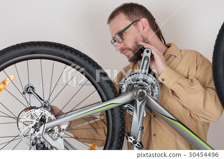 Bearded caucasian man repairing the mtb bicycle Bearded caucasian man repairing the mtb bicycle 30454496