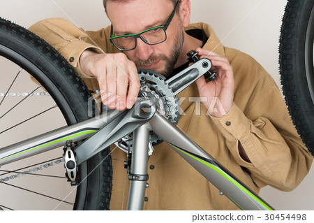 Bearded caucasian man repairing the mtb bicycle Bearded caucasian man repairing the mtb bicycle 30454498