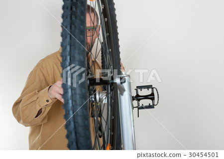 Bearded caucasian man repairing  the mtb bicycle 30454501