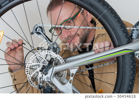 Bearded caucasian man repairing  the mtb bicycle 30454618