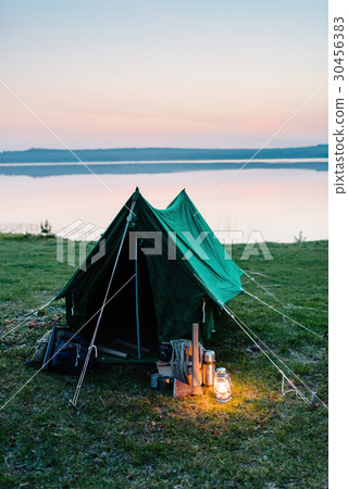 Tent on the shore of a lake, a lantern 30456383
