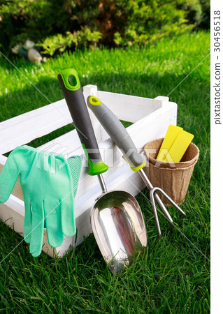 Gardening tools and a straw hat on the grass in 30456518