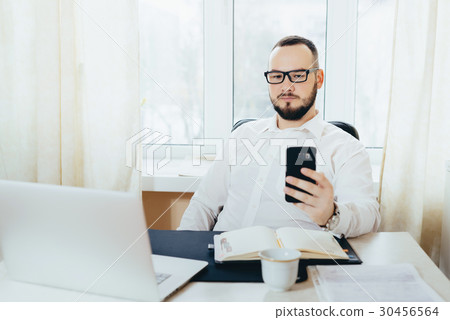 Portrait of a businessman looking in the phone 30456564