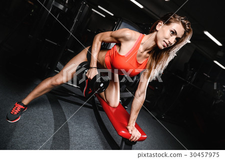 Beautiful sexy caucasian fitness girl training back in gym pumpi Beautiful sexy caucasian fitness girl training back in gym pumpi 30457975