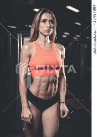 Caucasian sexy fitness female model in gym close up abs. 30457994
