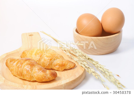 Double croissants and fresh eggs with wooden ware 30458378