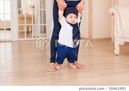 Mom teaching her son's first baby steps indoors 30463995