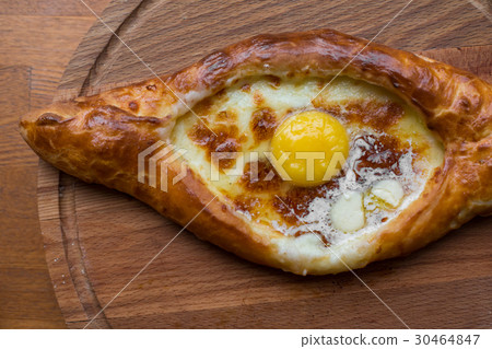 Adjara khachapuri on a wooden plate top view close Adjara khachapuri on a wooden plate top view close 30464847
