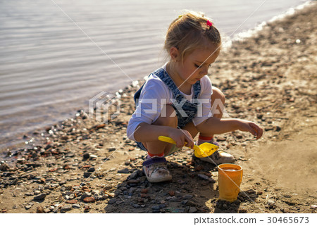 cute little girl play with sand and shovel on 30465673
