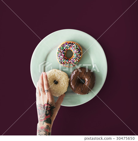 Hand with tattoo reaching for donut Hand with tattoo reaching for donut 30475650