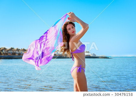 Young woman with curly hair  posing  with pareo  30476158