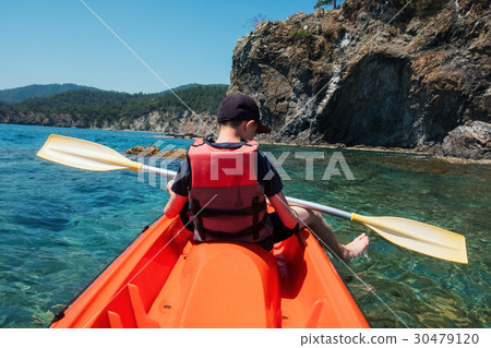 Boy in life jacket on orange kayak 30479120