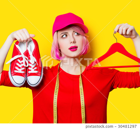 young woman with centimeter, gumshoes and hanger young woman with centimeter, gumshoes and hanger 30481297