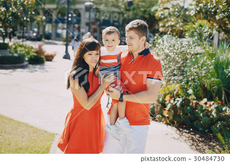 beautiful family in red walking down the street 30484730