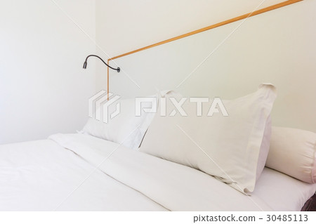 White bedroom with a king size bed and pillows. 30485113