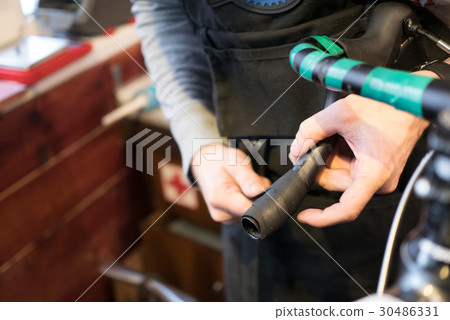 Man fixing bicycle in garage Man fixing bicycle in garage 30486331