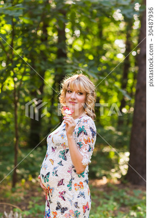 Outdoor portrait of young pregnant woman holding a 30487936