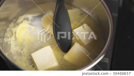 Handheld shot of butter melting in water 30488657