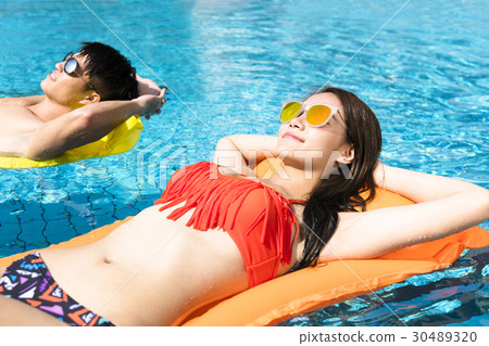 young couple relaxing on inflatable raft young couple relaxing on inflatable raft 30489320
