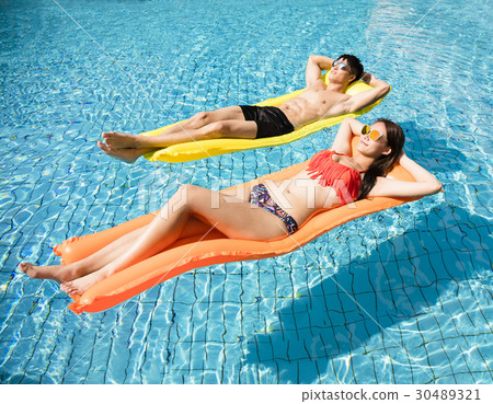 young couple relaxing on inflatable raft  30489321