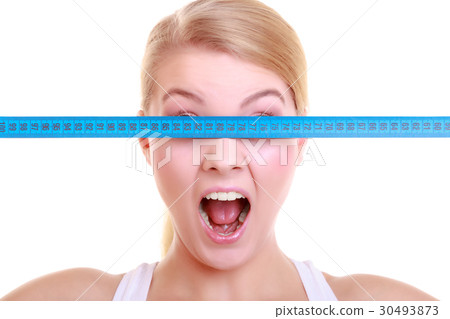 Fitness girl fit woman covering her eyes with measuring tape Fitness girl fit woman covering her eyes with measuring tape 30493873