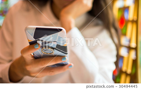 Girl using smartphone in a restaurant Girl using smartphone in a restaurant 30494445