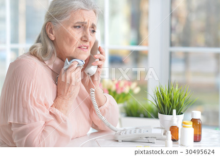 Beautiful old woman taking pills 30495624