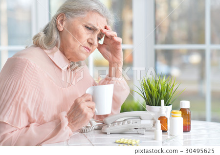 Beautiful old woman taking pills 30495625