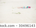 Bikini woman tanning relaxing on beach 30496143