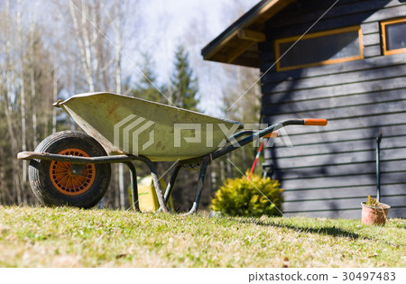 Garden wheelbarrow on the front of farm house 30497483