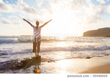 Free Happy Woman Enjoying Sunset on Sandy Beach 30498009
